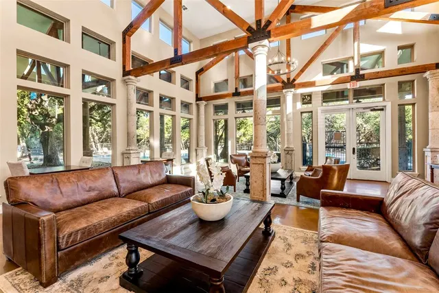 a dining room with wooden floor a chandelier a wooden table and chairs