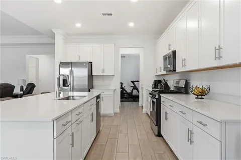 a kitchen with white cabinets sink and stainless steel appliances