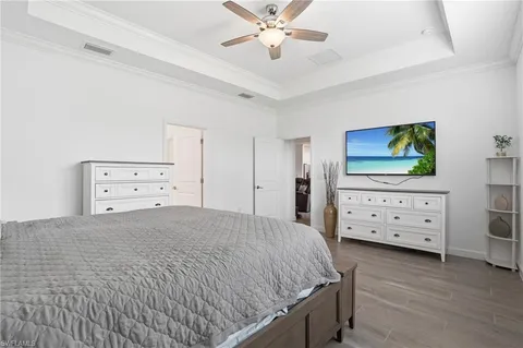 a bedroom with a bed and a flat tv screen on dresser