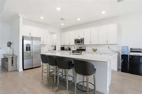 a kitchen with stainless steel appliances a table chairs refrigerator and microwave