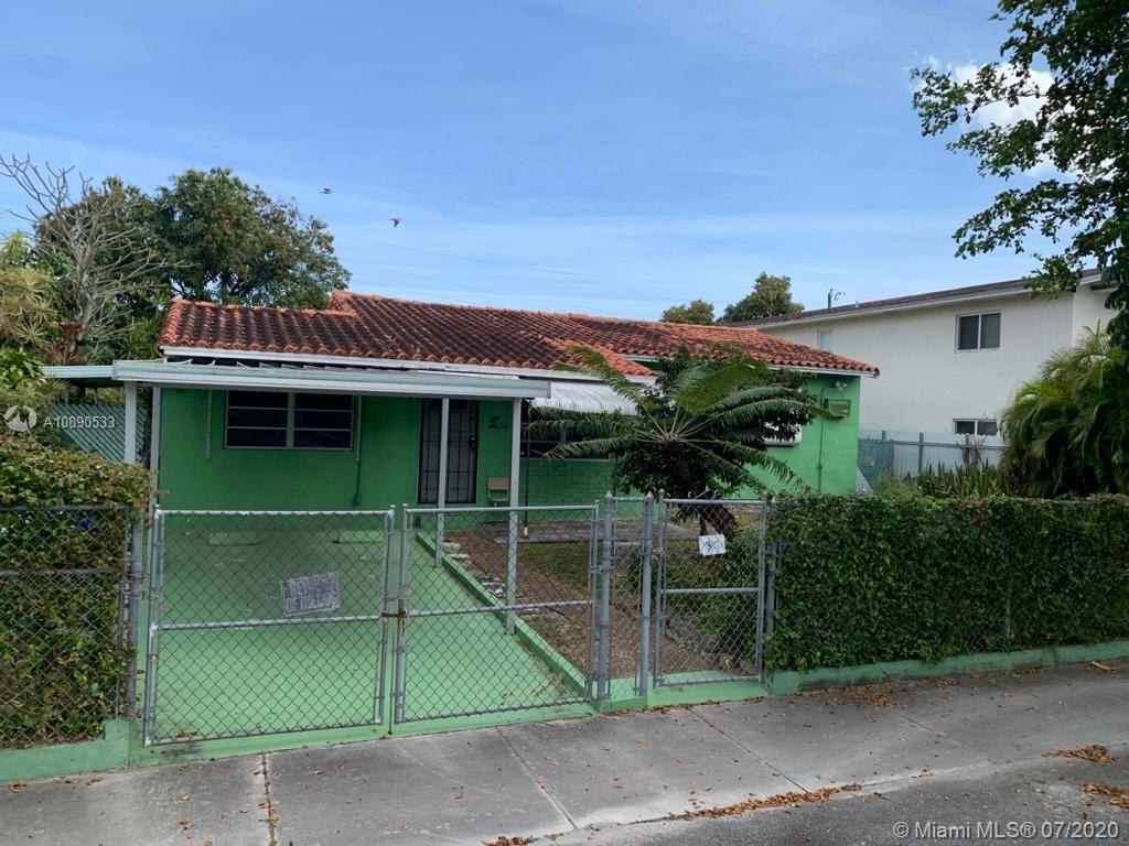 a front view of a house with plants