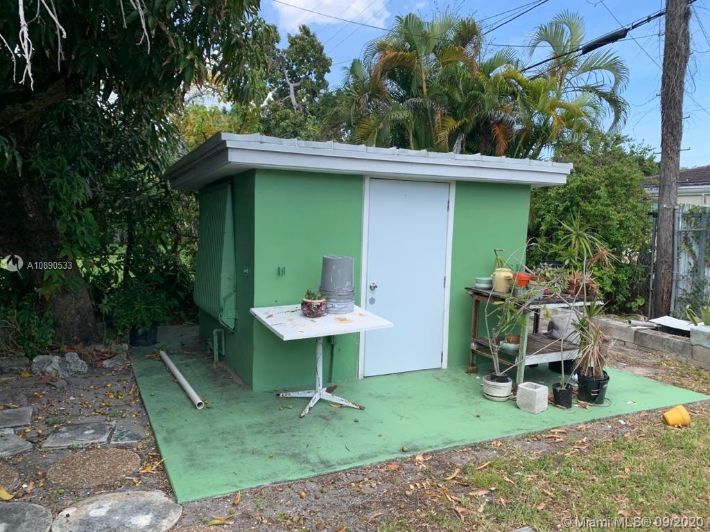 701 Tamiami Canal Road Miami, FL 33144 - Photo 12 of 13 a backyard of a house with table and chairs