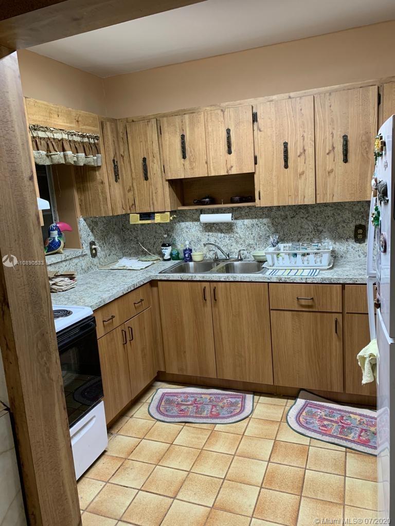 701 Tamiami Canal Road Miami, FL 33144 - Photo 3 of 13 a kitchen with granite countertop a sink a stove and cabinets
