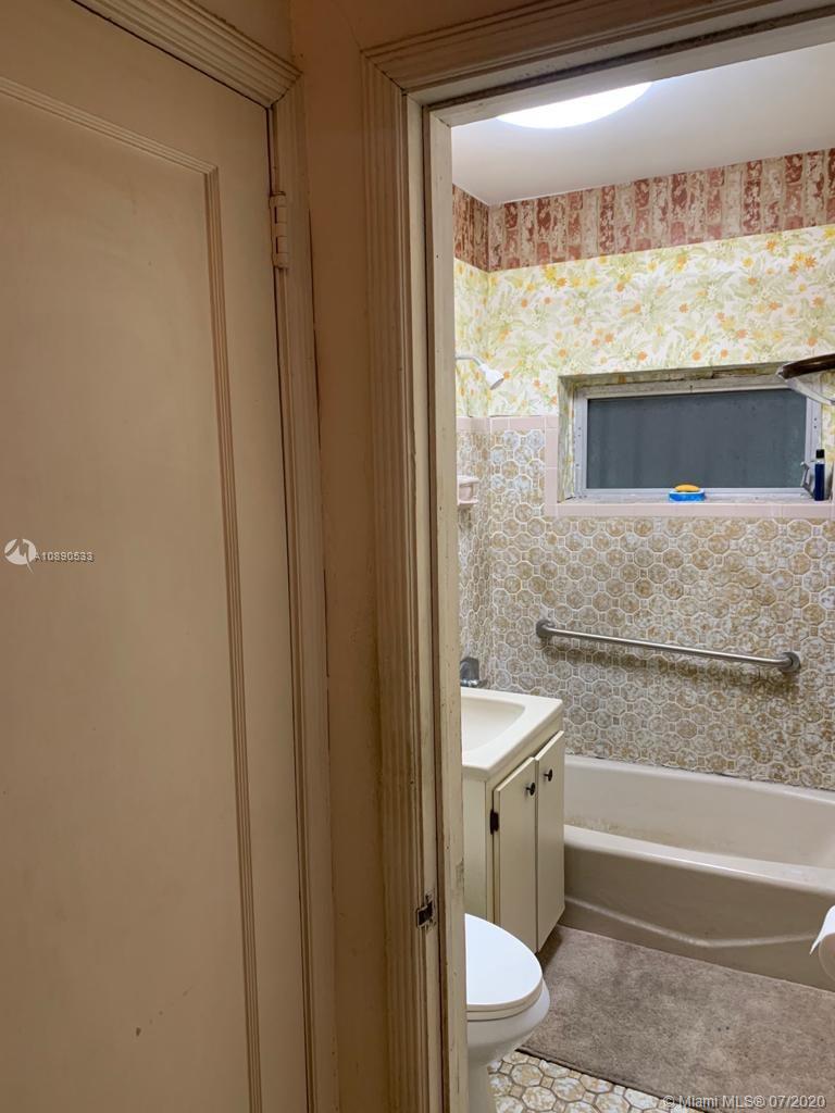 701 Tamiami Canal Road Miami, FL 33144 - Photo 4 of 13 a bathroom with a granite countertop toilet a sink and bathtub