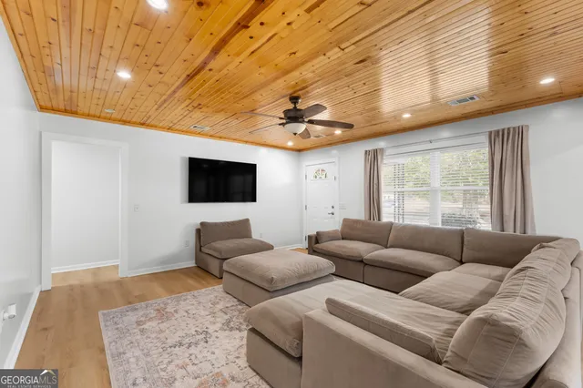 a living room with furniture a flat screen tv and a window