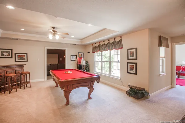 a room with pool table and windows