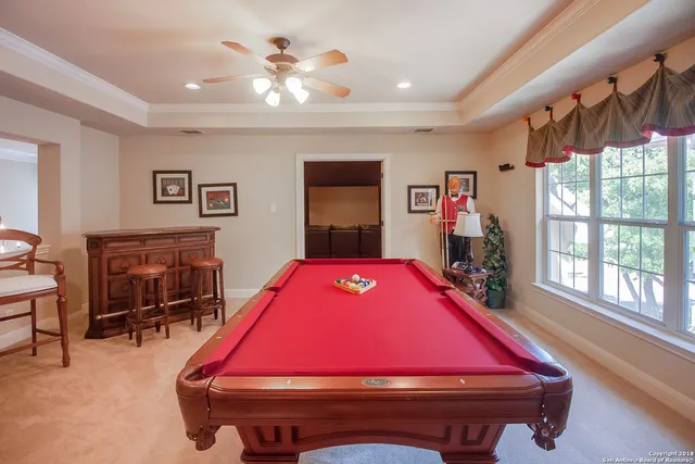 a room with pool table table and windows