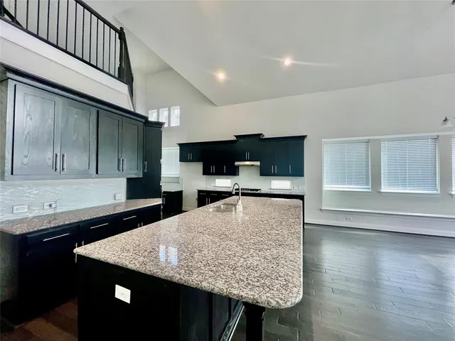 a kitchen with large counter space and wooden floor