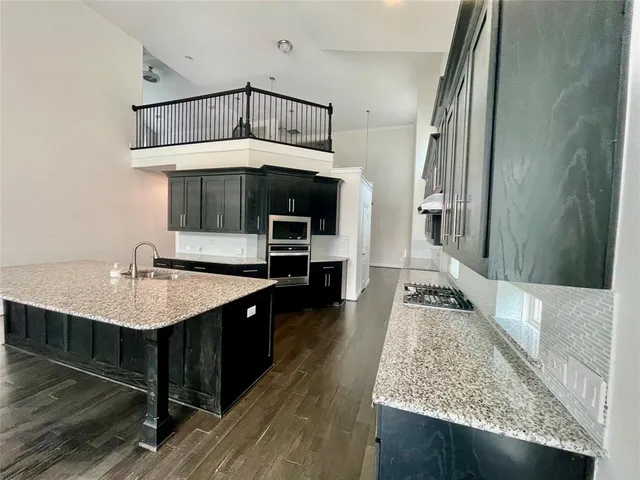 a kitchen with a sink a counter top space and stainless steel appliances