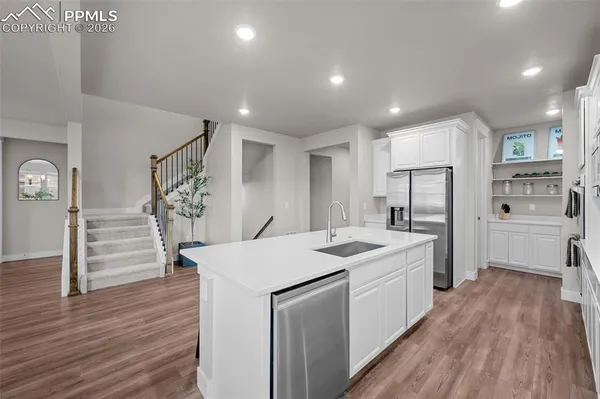 a kitchen with a sink a counter top space stainless steel appliances and cabinets
