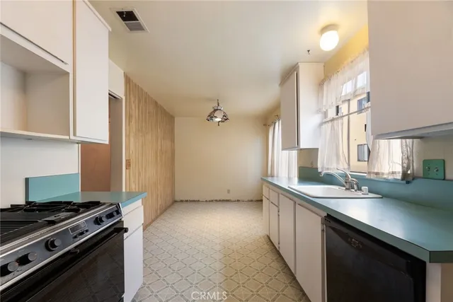 a kitchen with stainless steel appliances a sink stove and cabinets