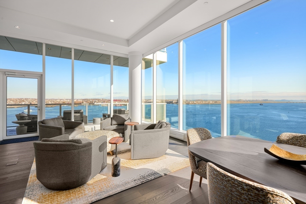 a living room with furniture and floor to ceiling windows