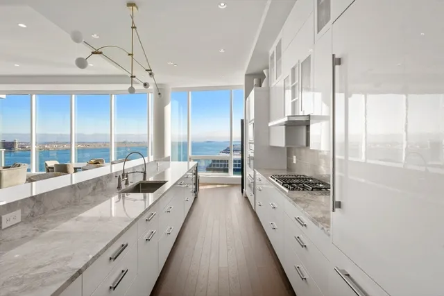 a dining hall with stainless steel appliances kitchen island granite countertop a dining table chairs and view living room