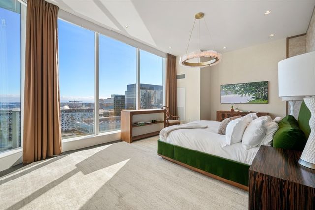 a spacious bedroom with a bed and a chandelier