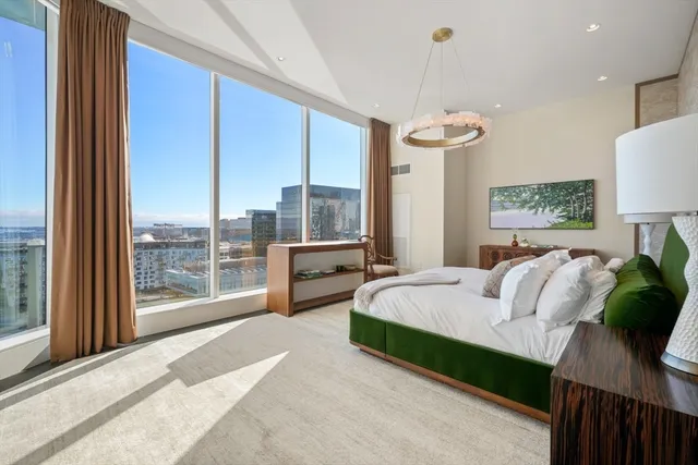 a spacious bedroom with a bed and a chandelier
