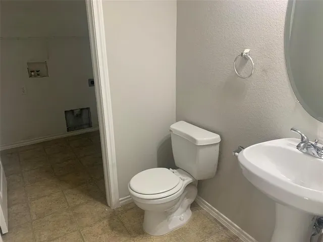 a white toilet sitting next to a bathroom sink and vanity