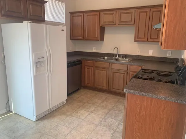 a kitchen with stainless steel appliances granite countertop a refrigerator and a stove