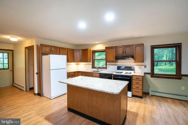 a kitchen with granite countertop a sink stove and refrigerator