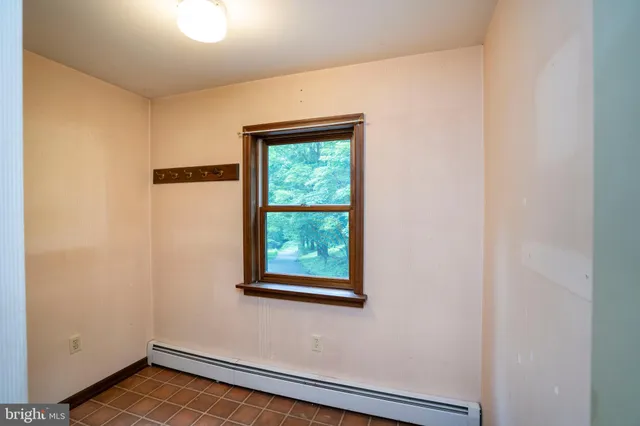 an empty room with a window and a ceiling fan