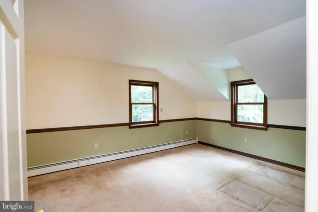 a view of hallway with window and wooden floor