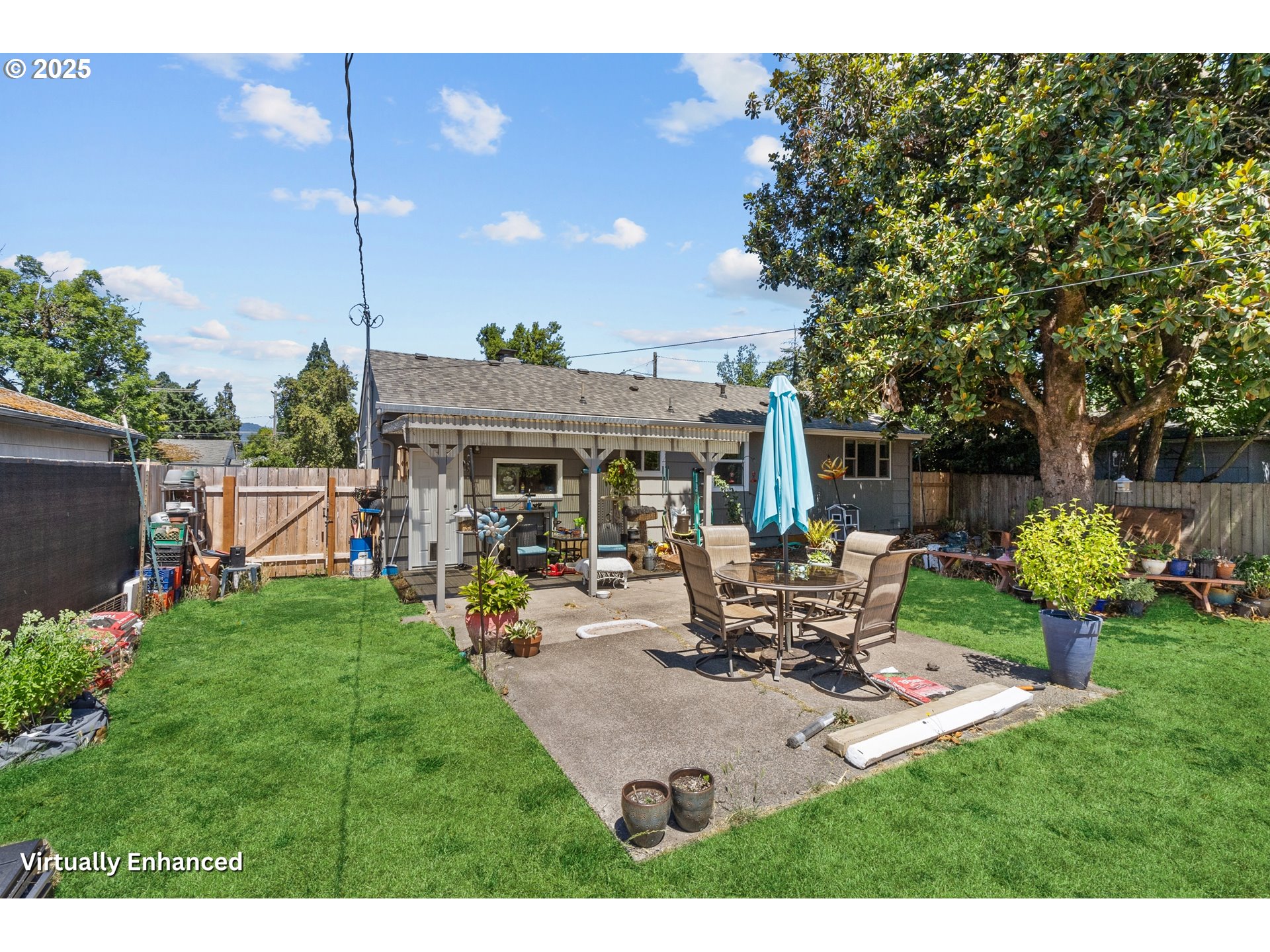2681 D Street Springfield, OR 97477 - Photo 6 of 24 a view of a patio with table and chairs potted plants and a large tree