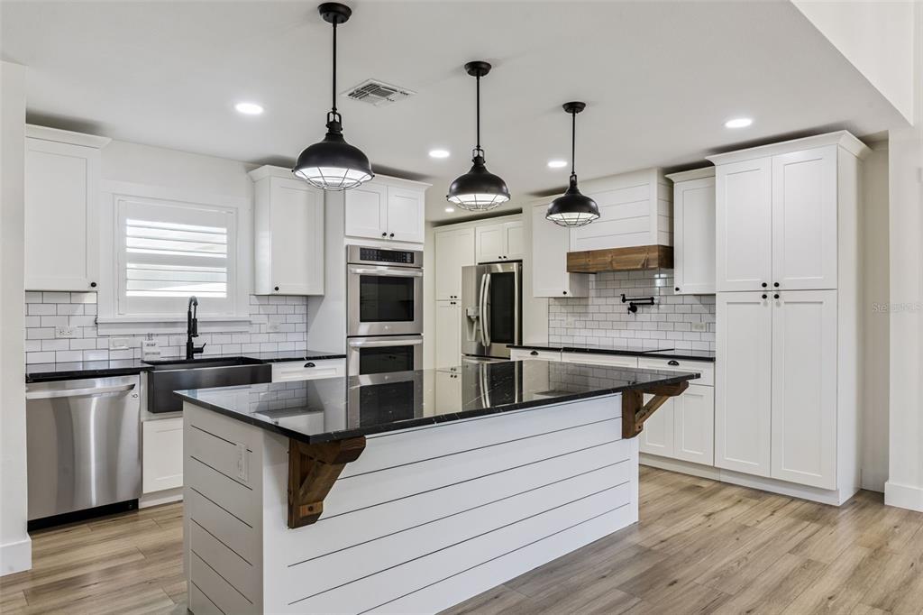 323 McLain Lane Geneva, FL 32732 - Photo 15 of 70 a kitchen with stainless steel appliances granite countertop a stove a sink and a refrigerator