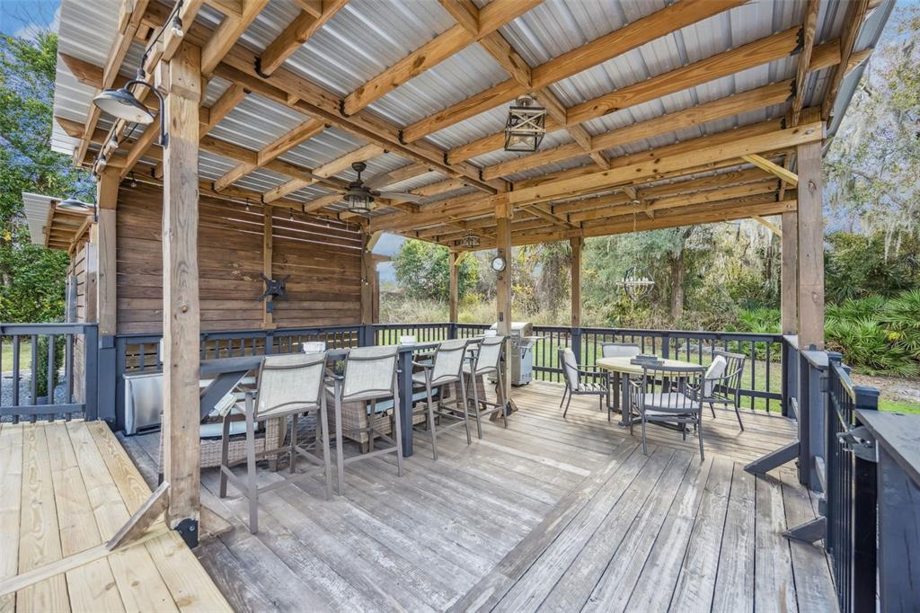 323 McLain Lane Geneva, FL 32732 - Photo 17 of 70 a view of a patio with table and chairs and wooden floor