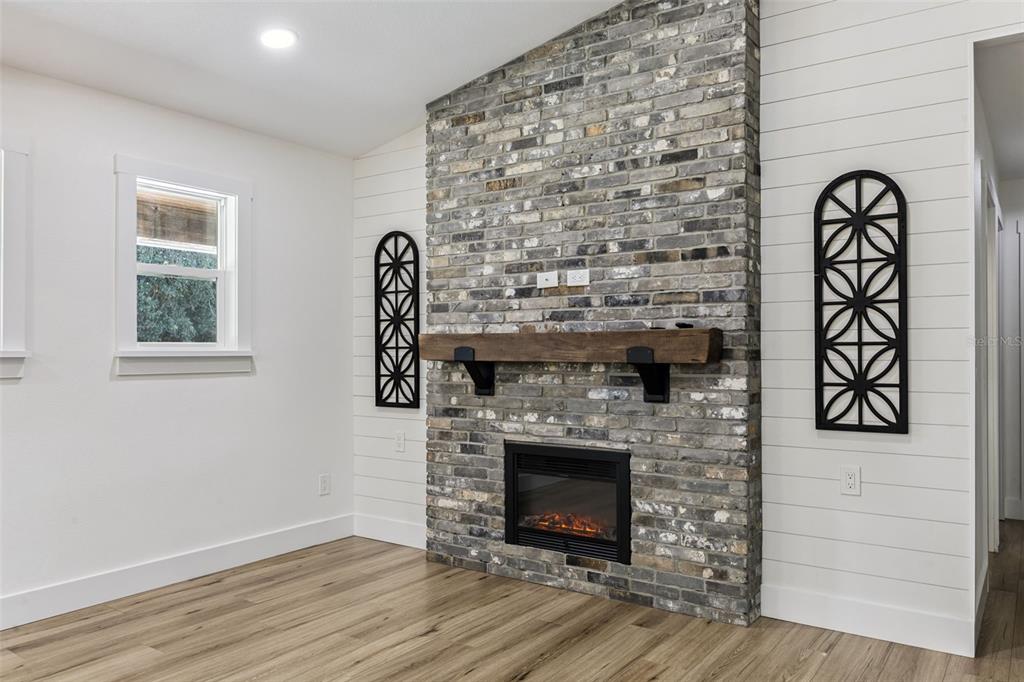 323 McLain Lane Geneva, FL 32732 - Photo 20 of 70 a living room with a wooden floor and a fireplace