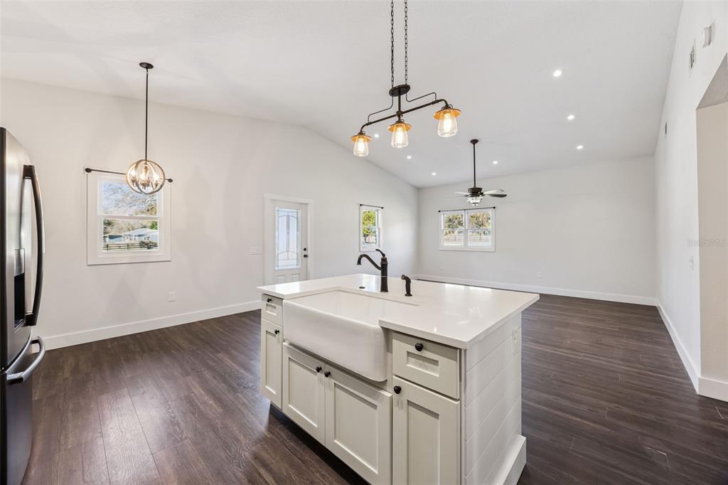 323 McLain Lane Geneva, FL 32732 - Photo 40 of 70 a view of a kitchen island a sink wooden floor and a ceiling fan