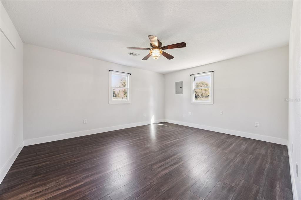 323 McLain Lane Geneva, FL 32732 - Photo 48 of 70 an empty room with wooden floor ceiling fan and windows