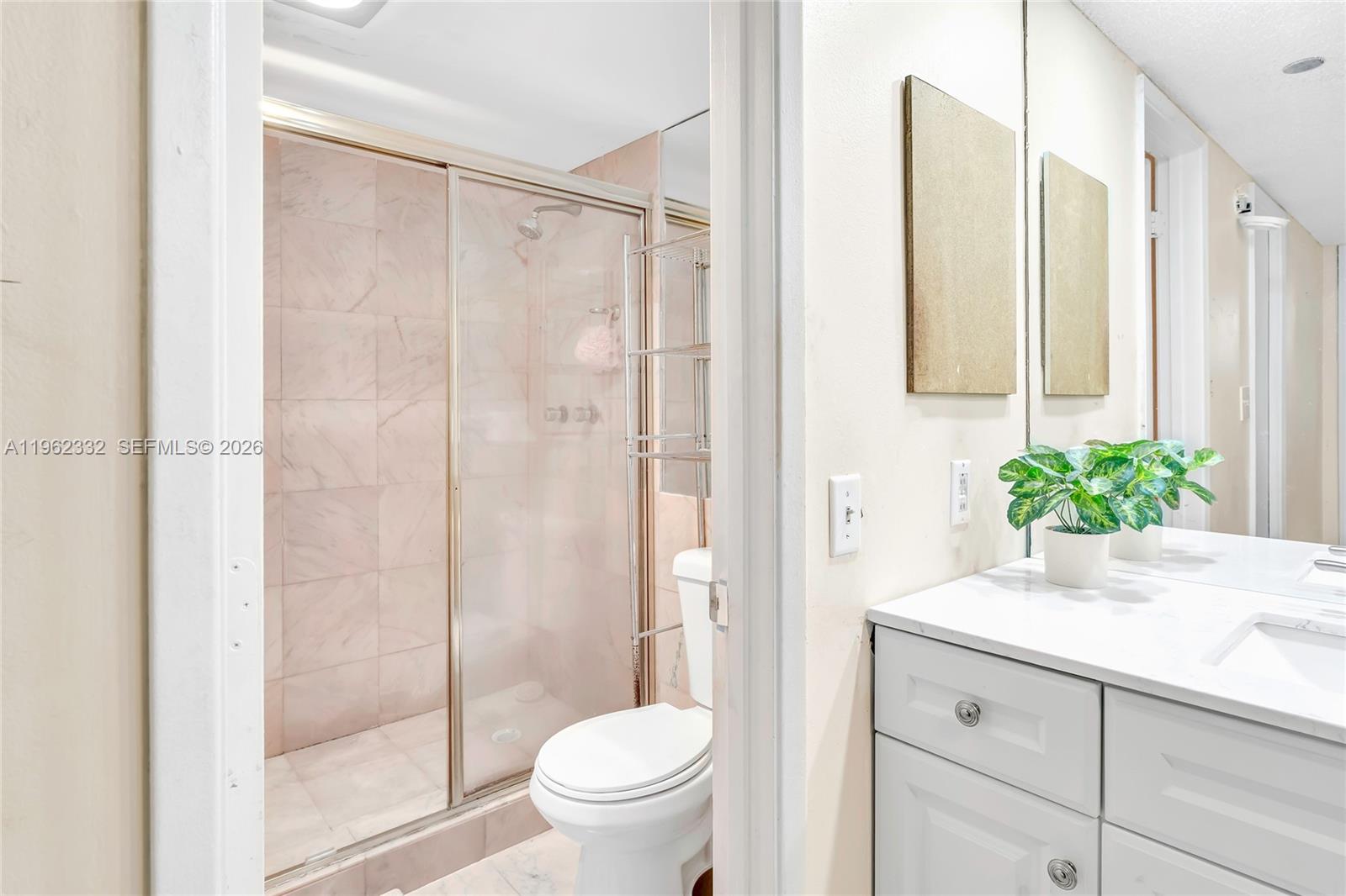 3510 Oaks Way, Unit 408 Pompano Beach, FL 33069 - Photo 23 of 27 a bathroom with a shower curtain a sink and a toilet