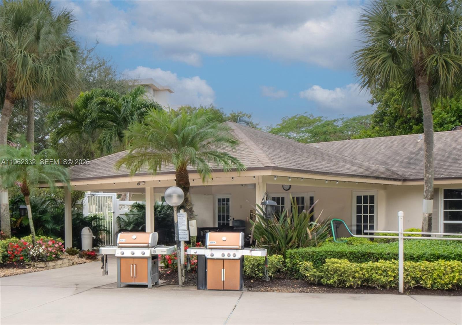 3510 Oaks Way, Unit 408 Pompano Beach, FL 33069 - Photo 24 of 27 a view of a patio with table and chairs potted plants and palm tree