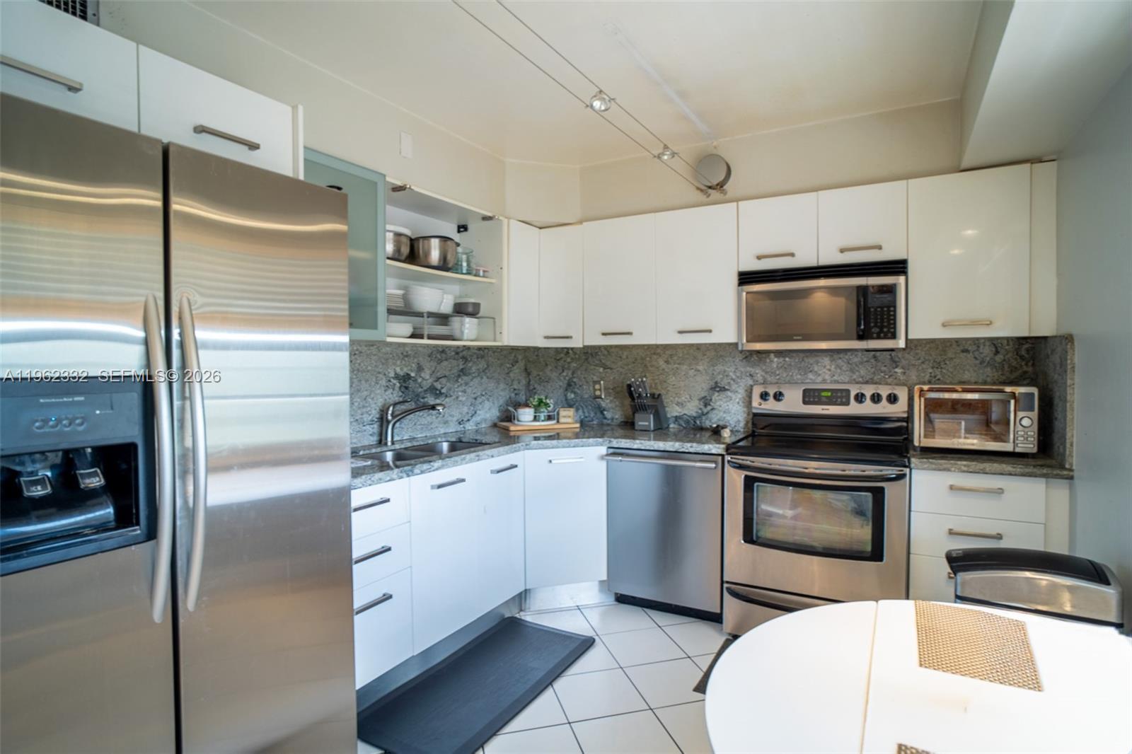 3510 Oaks Way, Unit 408 Pompano Beach, FL 33069 - Photo 9 of 27 a kitchen with stainless steel appliances granite countertop a refrigerator a stove a sink and a microwave