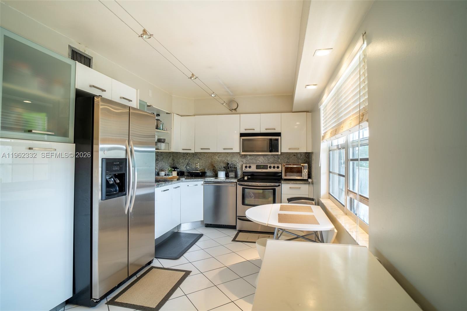 3510 Oaks Way, Unit 408 Pompano Beach, FL 33069 - Photo 10 of 27 a kitchen with stainless steel appliances kitchen island granite countertop a refrigerator and a stove top oven