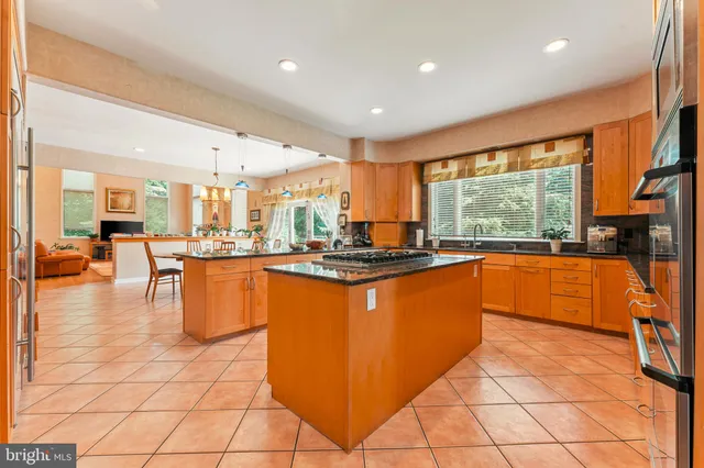 a kitchen with stainless steel appliances kitchen island granite countertop a refrigerator and wooden cabinets