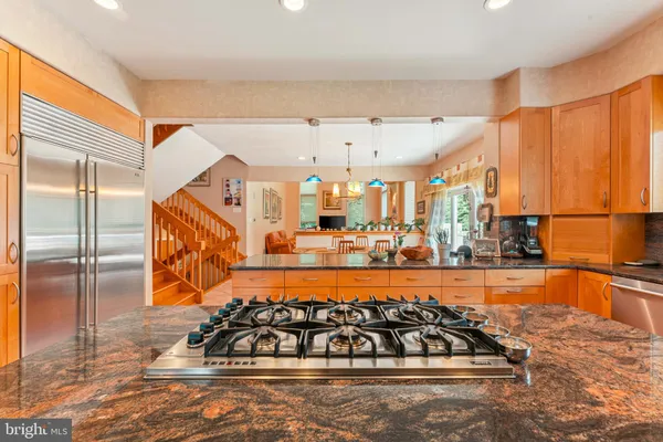 a living room with stainless steel appliances furniture windows and a rug