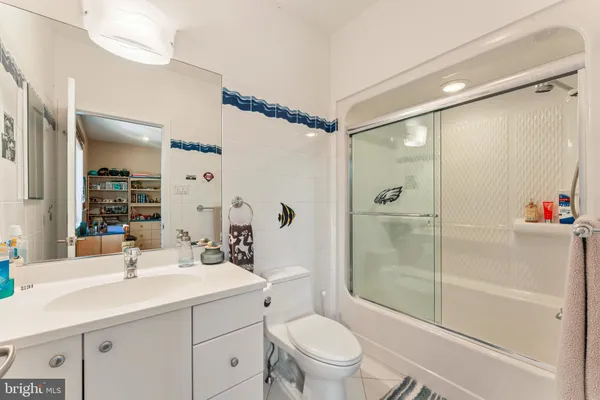 a bathroom with a shower sink vanity mirror and toilet