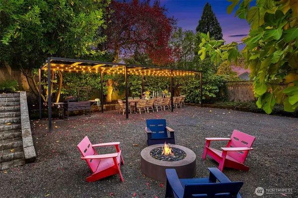 a backyard of a house with fire pit and outdoor seating