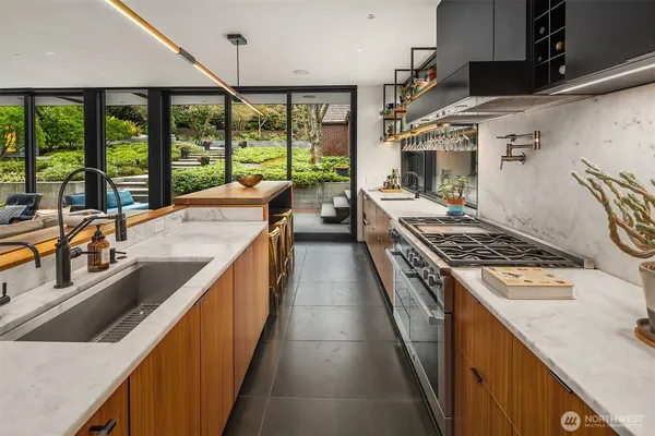 a kitchen with stainless steel appliances granite countertop sink stove and large window