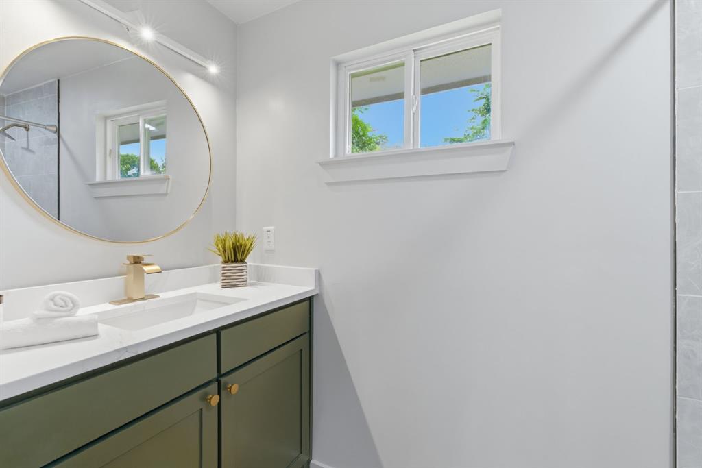 507 Country Club Road Cleburne, TX 76033 - Photo 23 of 39 Bathroom vanity featuring a white countertop, undermount sink, and gold-finish faucet