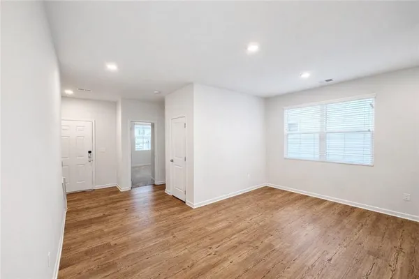 a view of an empty room with wooden floor