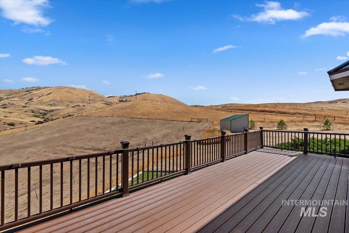 11660 Timber Butte Road Sweet, ID 83670 - Photo 40 of 49 Expansive outdoor deck featuring wood-finish composite decking and dark wood railings, offering panoramic hillside scenery