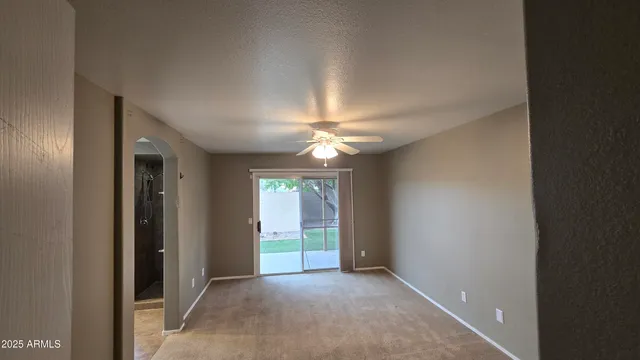 an empty room with closet and a chandelier fan
