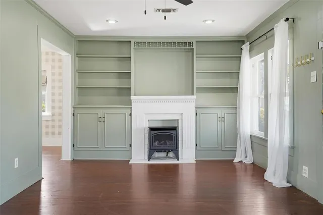 a view of a livingroom with a fireplace wooden floor and window