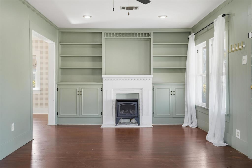a view of a livingroom with a fireplace wooden floor and window