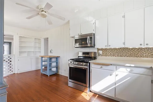 a kitchen with granite countertop a stove a sink and a microwave