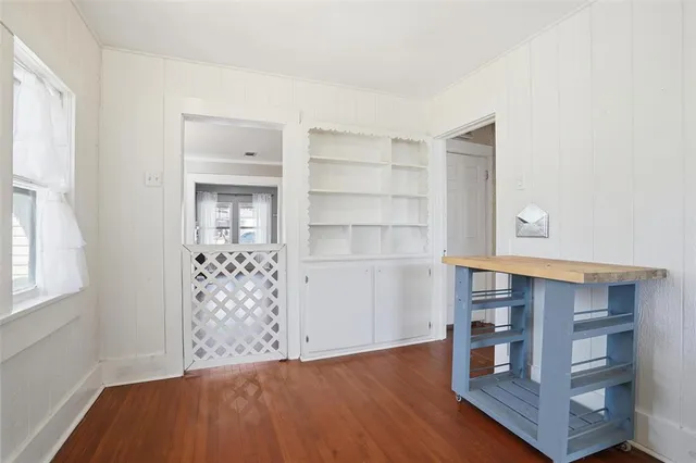 an empty room with cabinet and windows