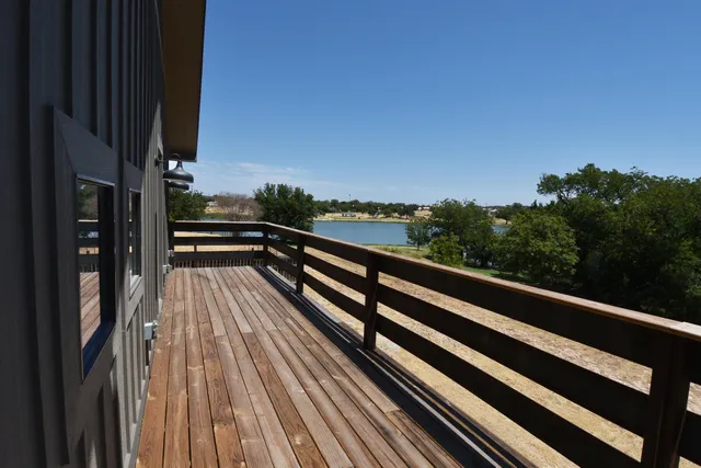 a view of balcony with wooden floor and fence
