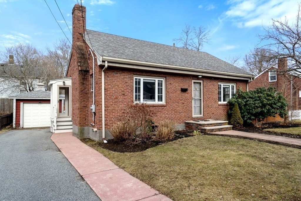 a brick house with tree in front of it