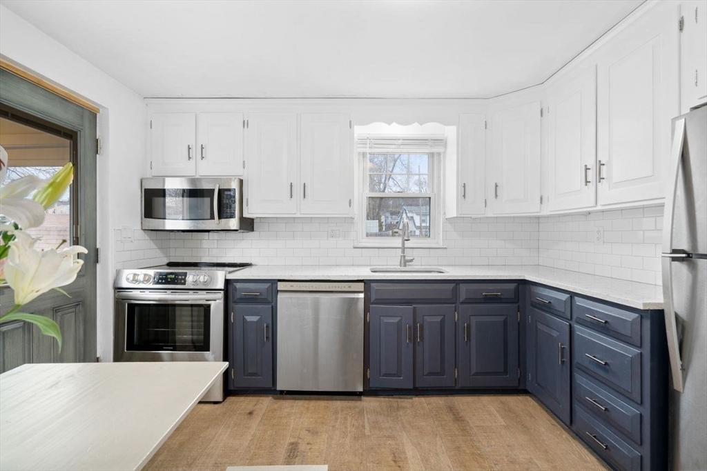68 Sutcliffe Road Lynn, MA 01904 - Photo 4 of 15 a kitchen with stainless steel appliances granite countertop a stove sink and microwave